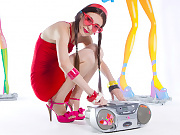 Adorable teen with red glasses in the shape of hearts and a tape recorder taking off her clothes